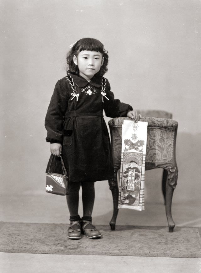 A Japanese girl in a dress, handbag, and flats holding Chitose Ame candy, which is traditional for the Japanese Shichi-Go-San (seven-five-three) holiday