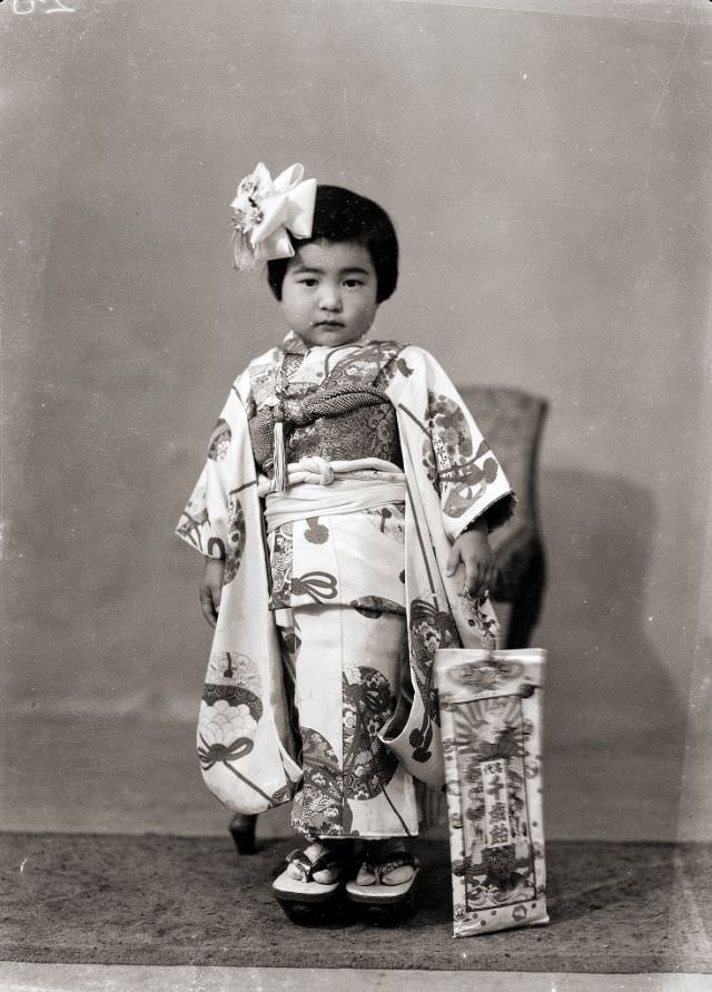 A Japanese girl in a kimono and hair bow with traditional Japanese Shichi-Go-San candy