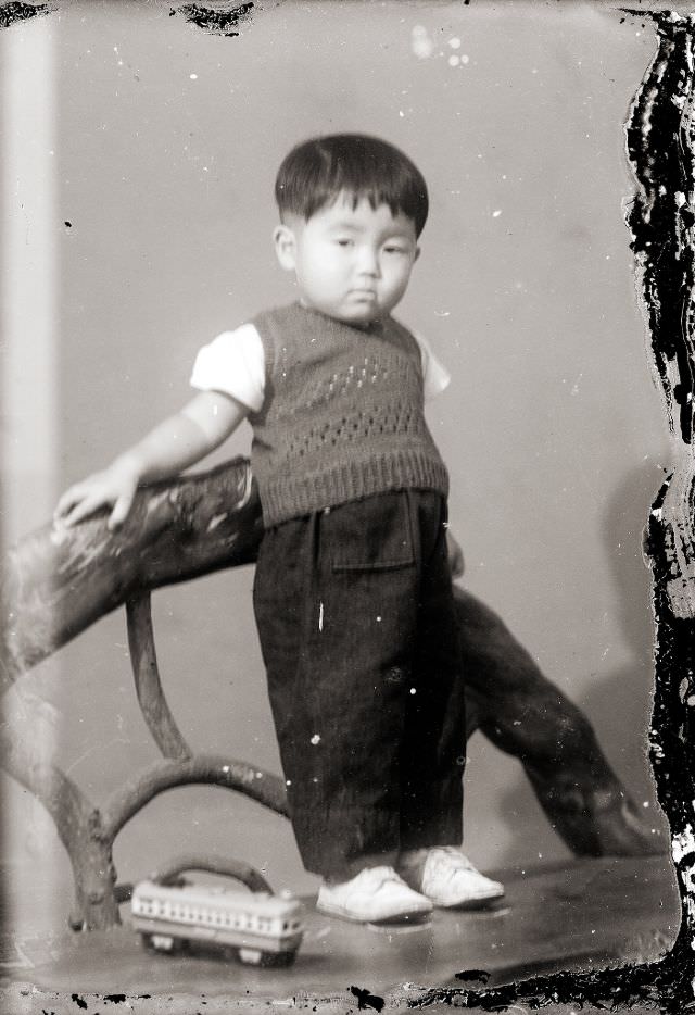 A young Japanese boy in a sweater vest