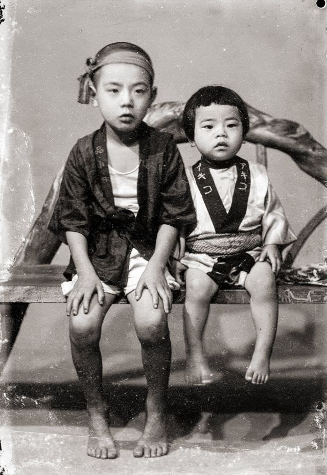 A Japanese boy and Japanese girl in traditional happi coats (he is wearing a headband as well)