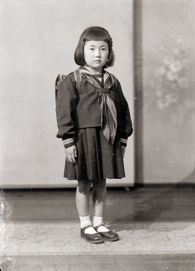 A young Japanese girl in a sailor school uniform with tie and backpack