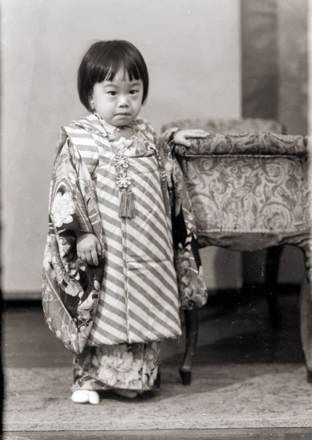 A young Japanese girl posing for a portrait in a kimono