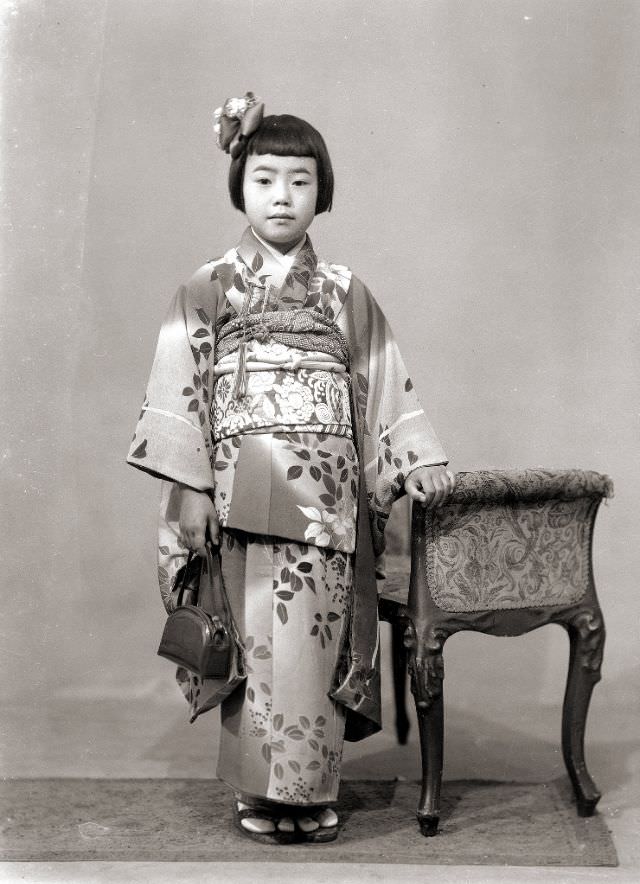 A young Japanese girl wearing a kimono and holding a handbag