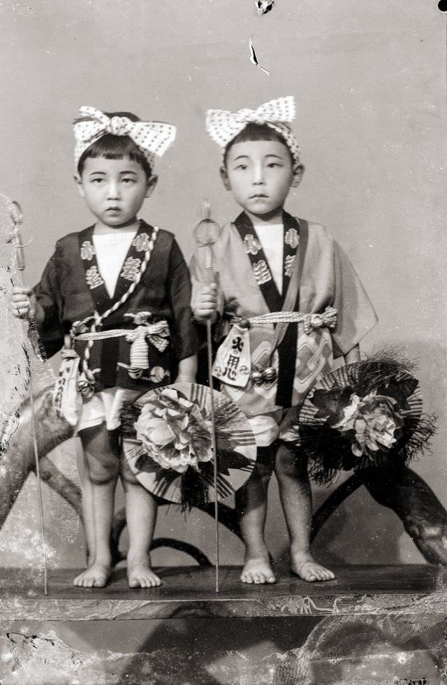 Two Japanese boys in traditional happi coats and headbands (with bows)