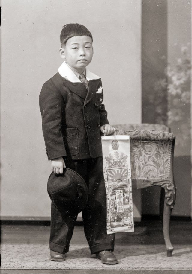 A Japanese boy posing for a portrait with traditional Chitose Ame candy for Shichi-Go-San holiday