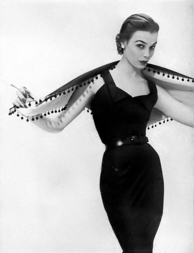 Lillian Marcuson in black silk broadcloth sheath dress with pom-pom trimmed shawl by Edwin, Glamour, April 1951
