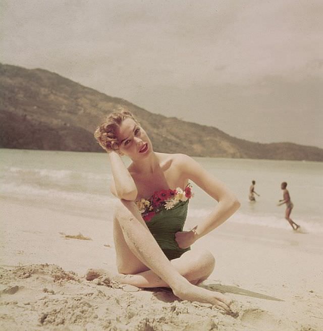 Lillian Marcuson in strapless one-piece bathing suit adorned with cotton flowers by Catalina, at Magen's Bay, St. Thomas, Life, May 21, 1951