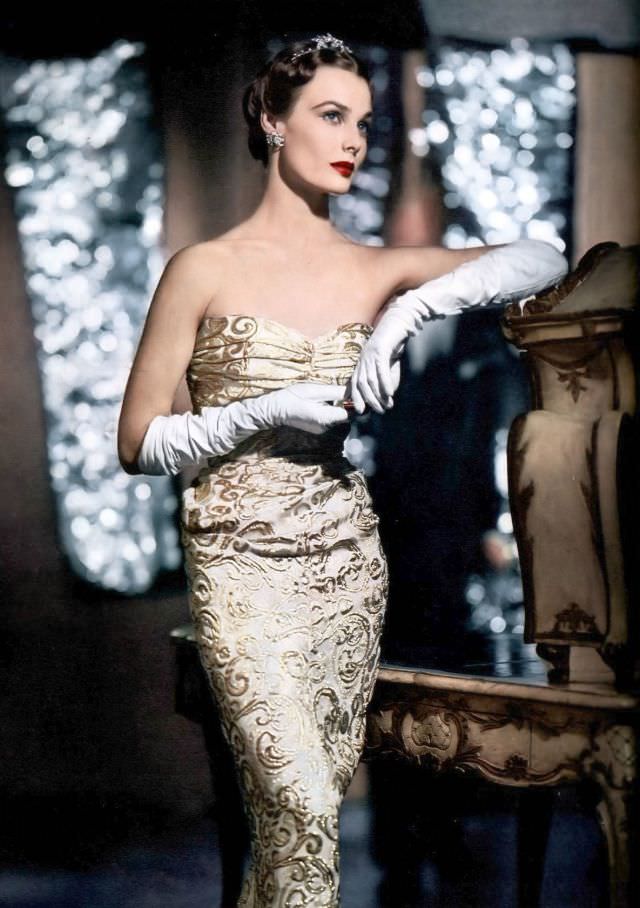 Lillian Marcuson in gold metallic evening gown with back panels sweeping to the ground by Adrian, Vogue, November 1, 1950