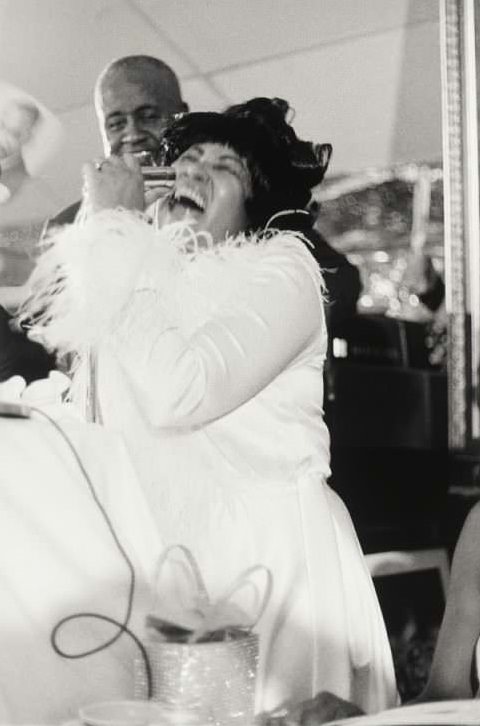 Made by Ernest C. Withers. Photograph of Aretha Franklin in a white jacket with feathery cuffs, sings into a microphone – Smithsonian