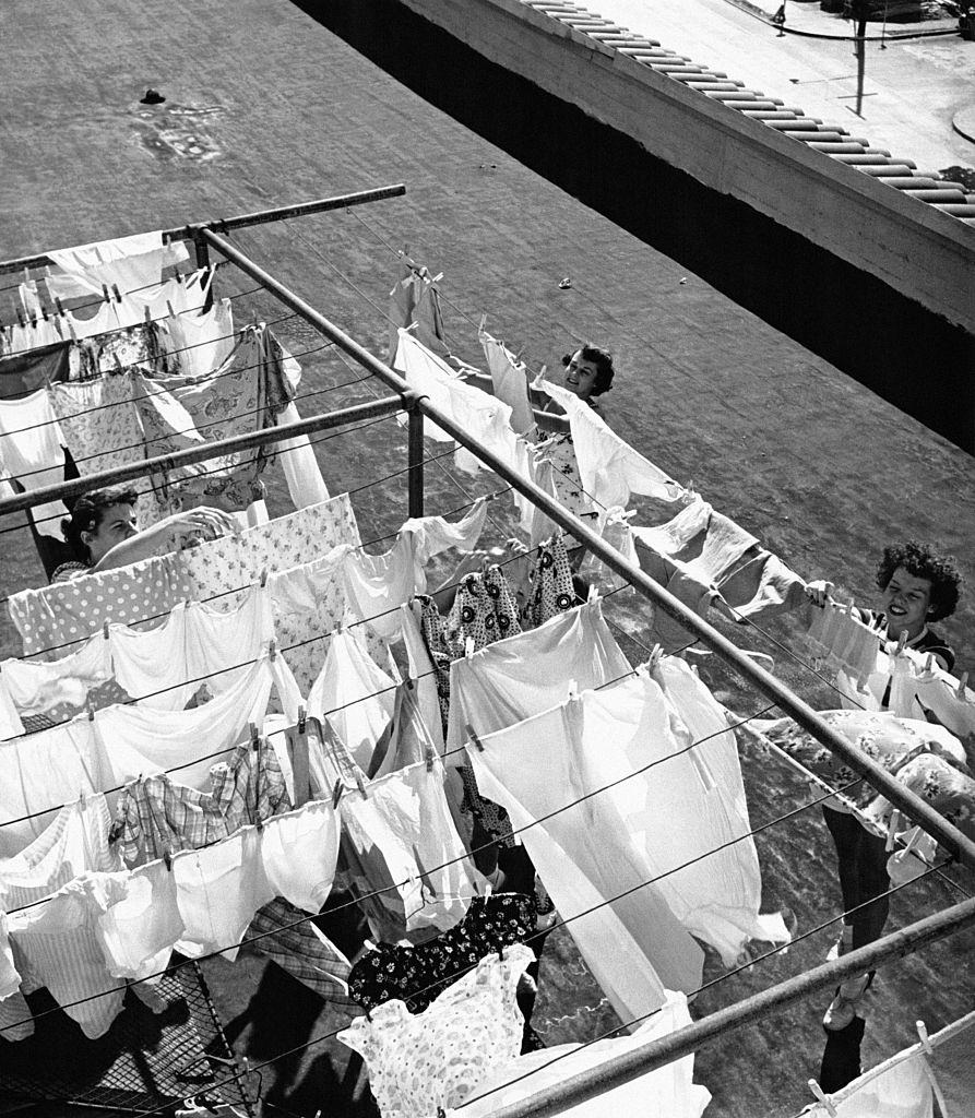 Young women hanging out their laundry on the roof of the YWCA (Young Woman Christian Association) 'Blue Triangle Club' in Oakland, 1940s.