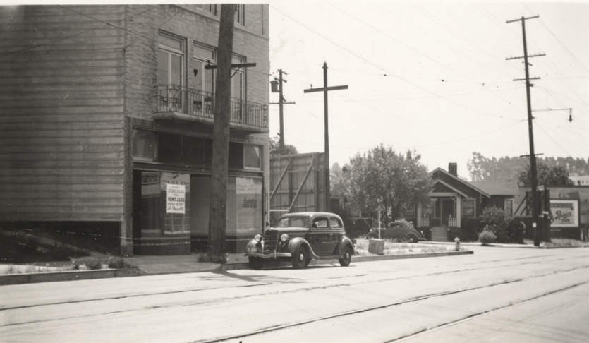 Vacant storefront with parked car on College Avenue near Kales Avenue, 1940s