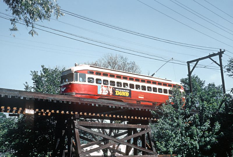 A Shannon-Drake car crossing on gauntlet single track wooded trestle over Saw Mill Run Parkway at Colerain St in Pittsburgh, PA on June 26, 1965