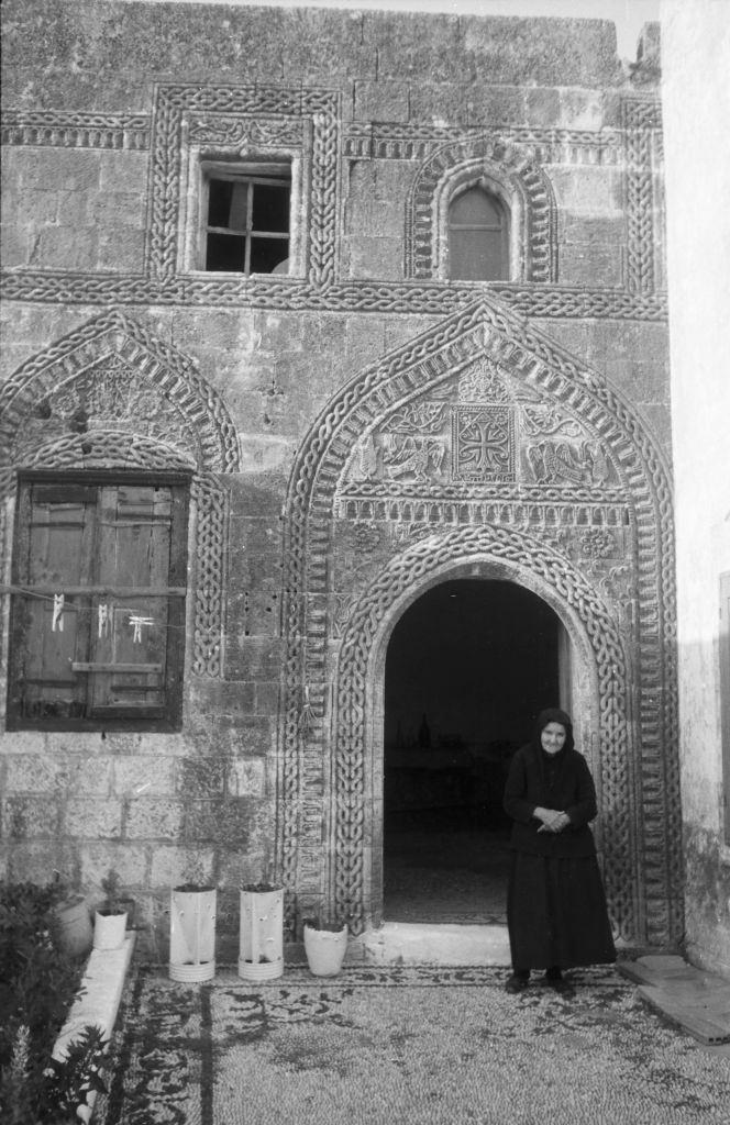 A woman in front of the front door to her house in Rhodes, Greece, 1950s.