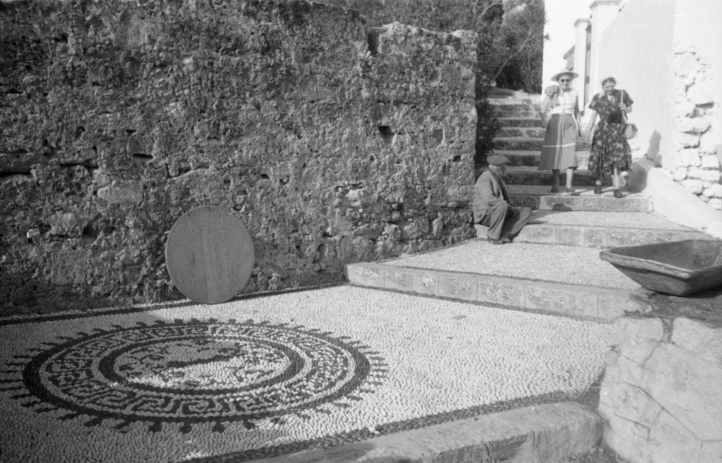 A man and two tourists in an alley of Lindos on Rhodes, Greece, 1950s.