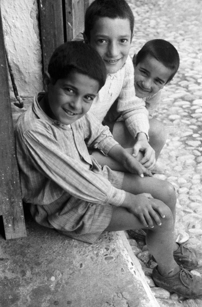 Three boys from the island of Rhodes laugh at the photographer, Greece, 1950s.