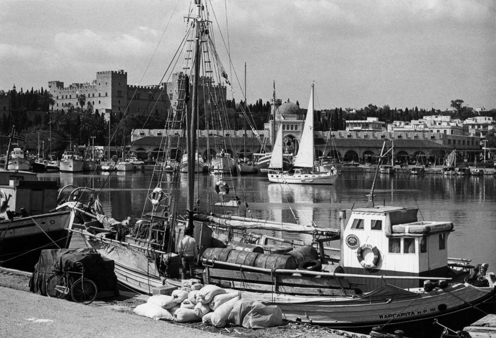 Trawler in the port of Rhodes, in front of the Palace of the Grand Masters, Greece, 1970.