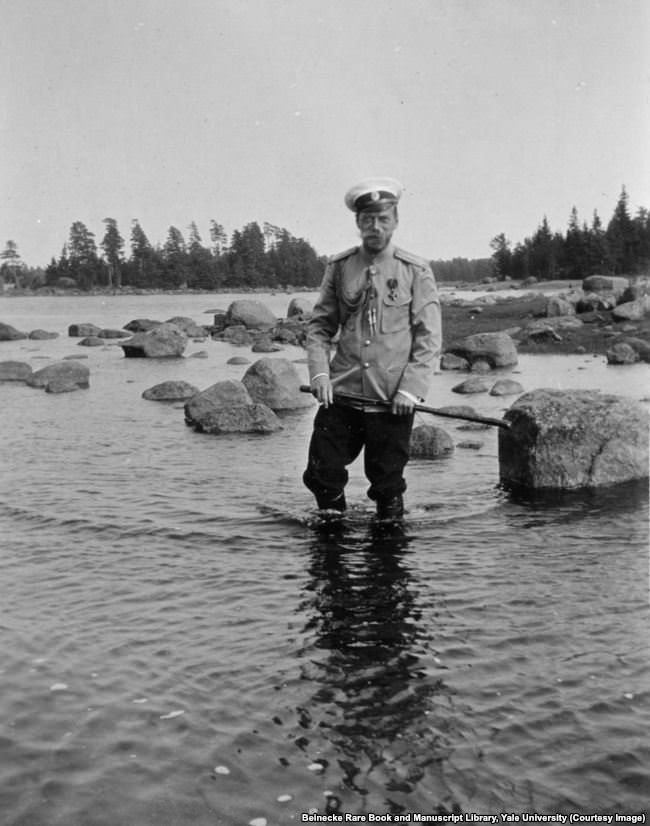 Tsar Nicholas II wading on the rocky shore of Finland.