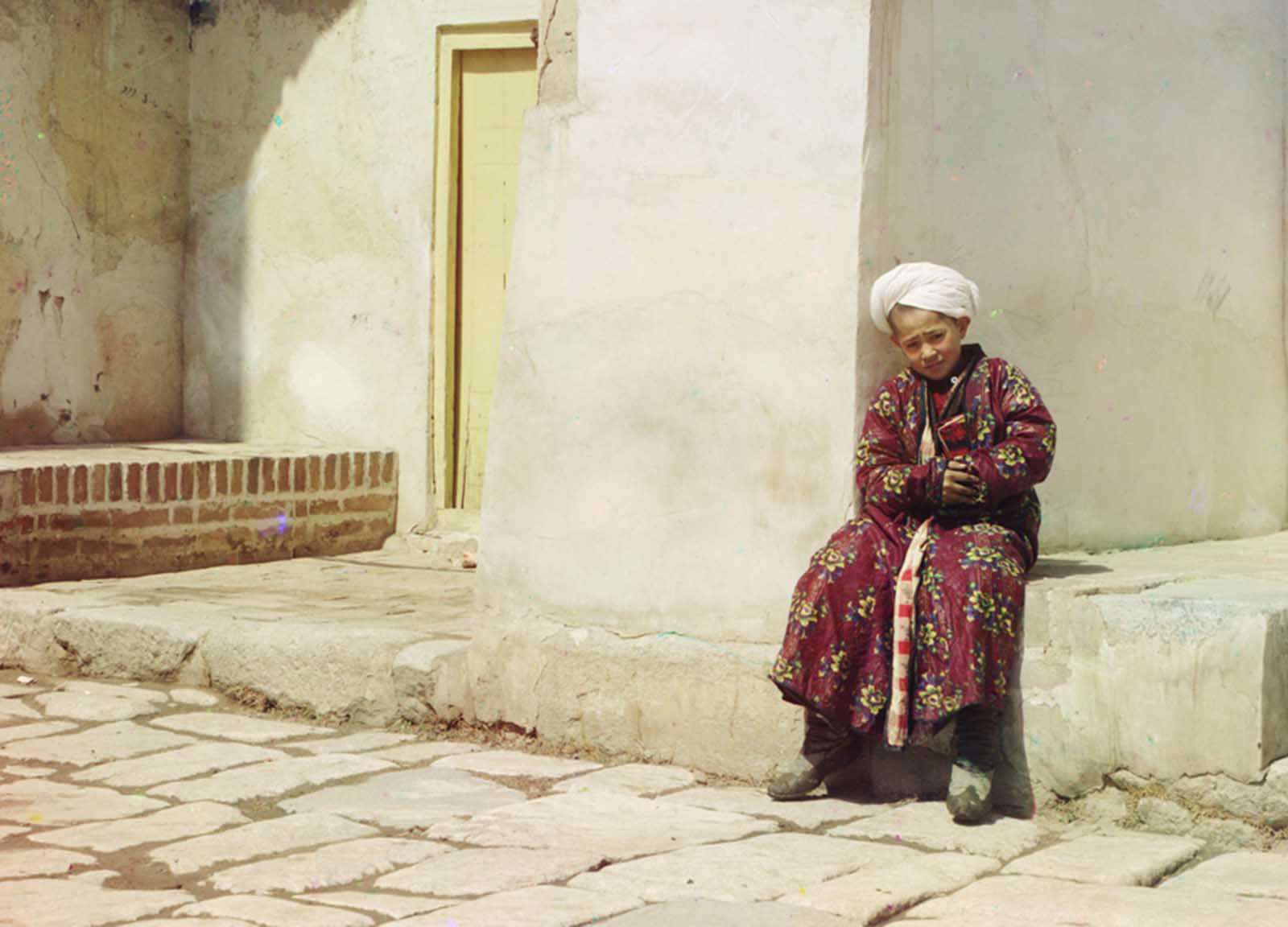 A boy sits in the court of Tillia-Kari mosque in Samarkand, present-day Uzbekistan, 1910.