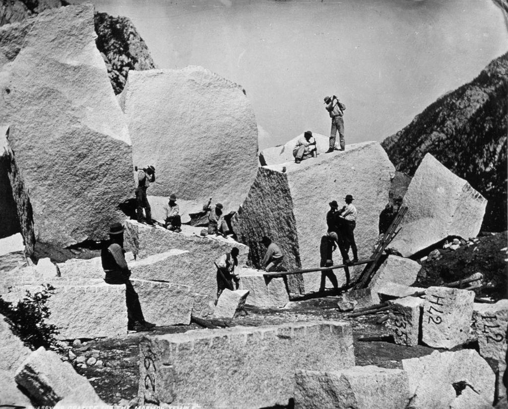 Stonecutters split granite boulders in Cottonwood Canyon, Utah, for use in building the Mormon Tabernacle in Salt Lake City.