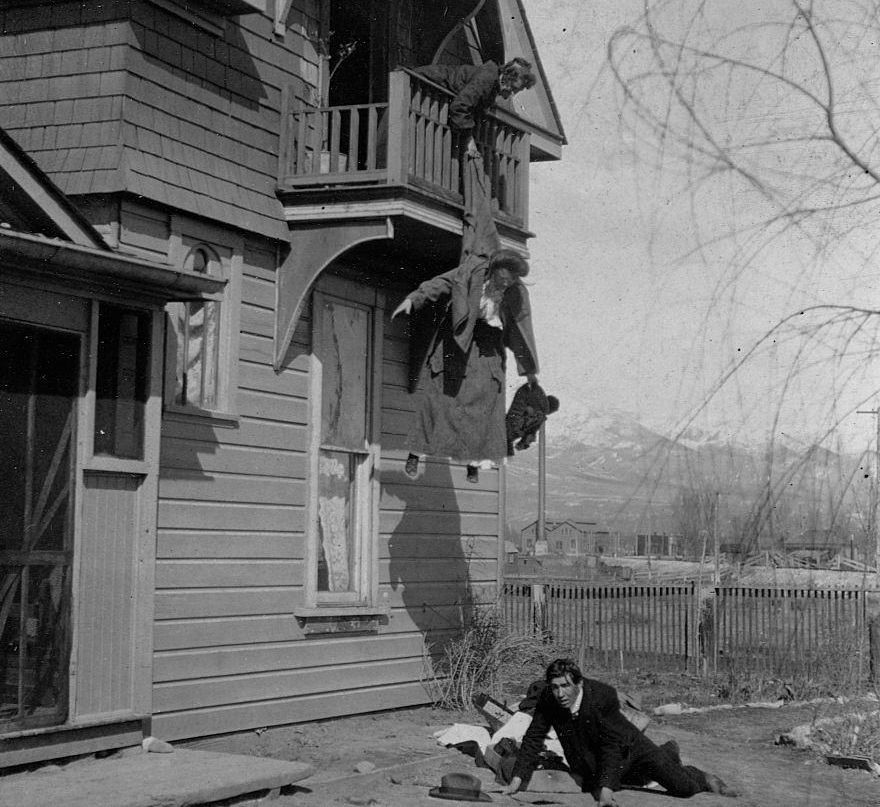 A mother holding her daughter from a balcony, preventing her elopement with a man sprawled on the ground below, 1905.