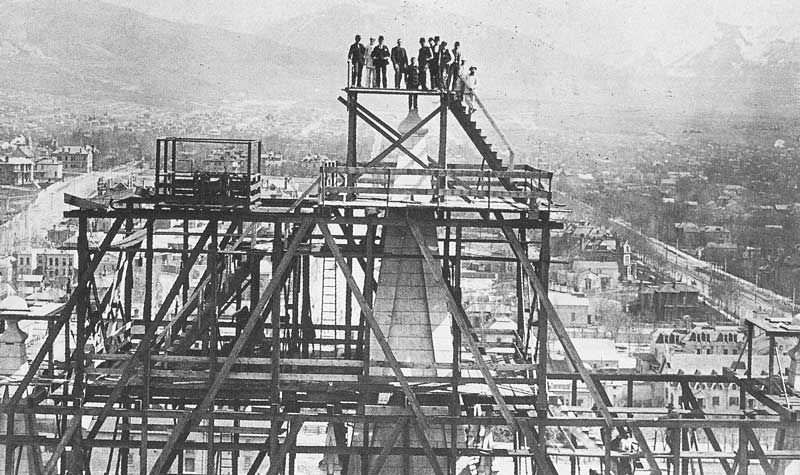 Situated on the opposite tower, Carter photographed temple workers standing on the pinnacle where the capstone was to be lowered into place.