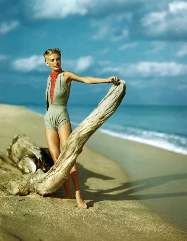 Model wearing gray V-midriff swim suit with polka-dot ascot, by Claire McCardell, 1945