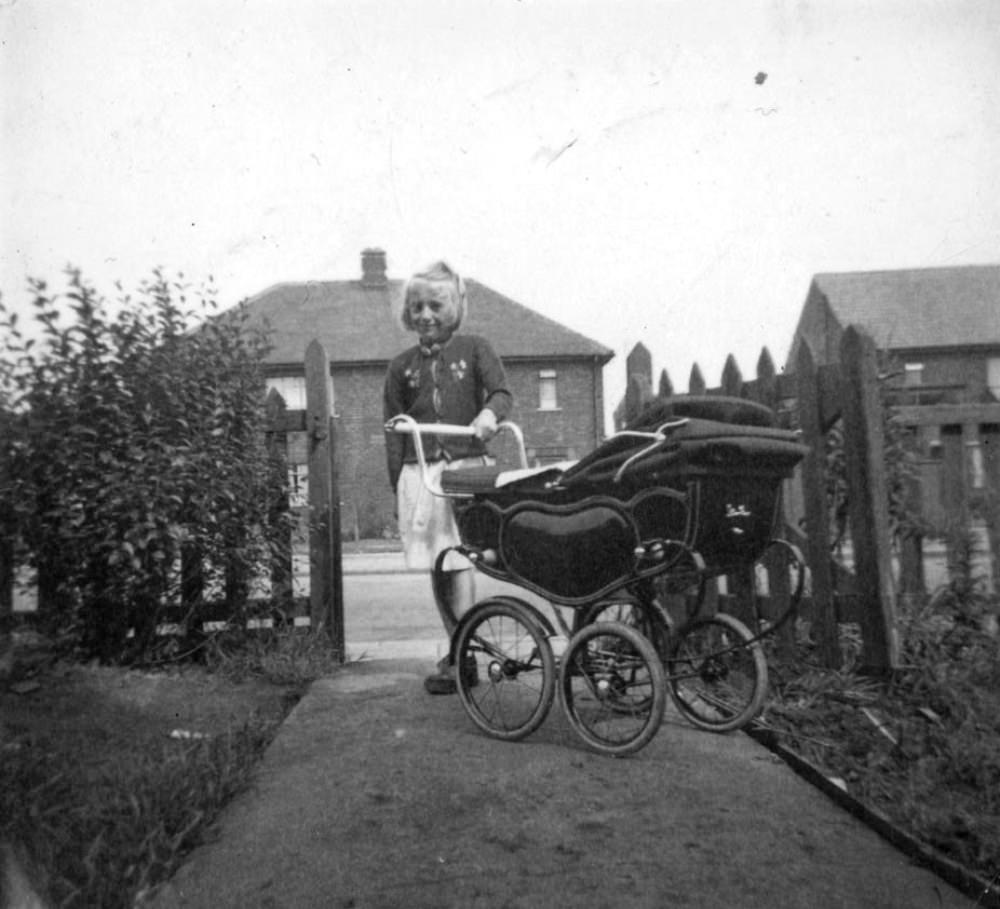 A young girl, a former patient at Stannington Sanatorium, with a dolls’ pram.