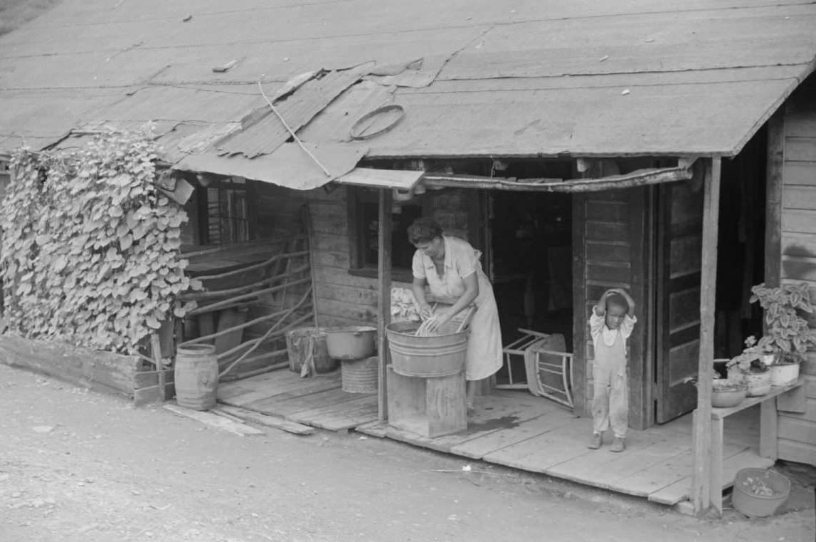 Coal miner’s wife washing clothes on front porch, Chaplin, West Virginia, 1938.