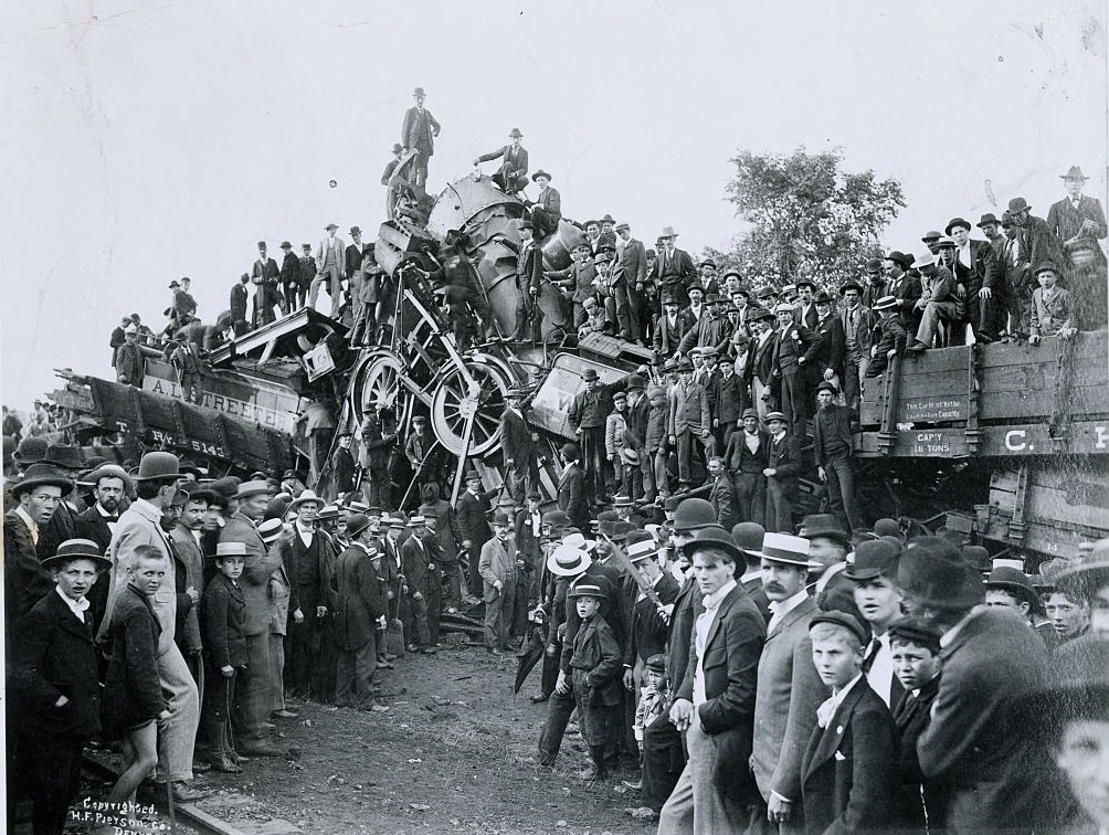 Crowds climbing over railroad wreckage in hopes of finding souvenirs, 1896.