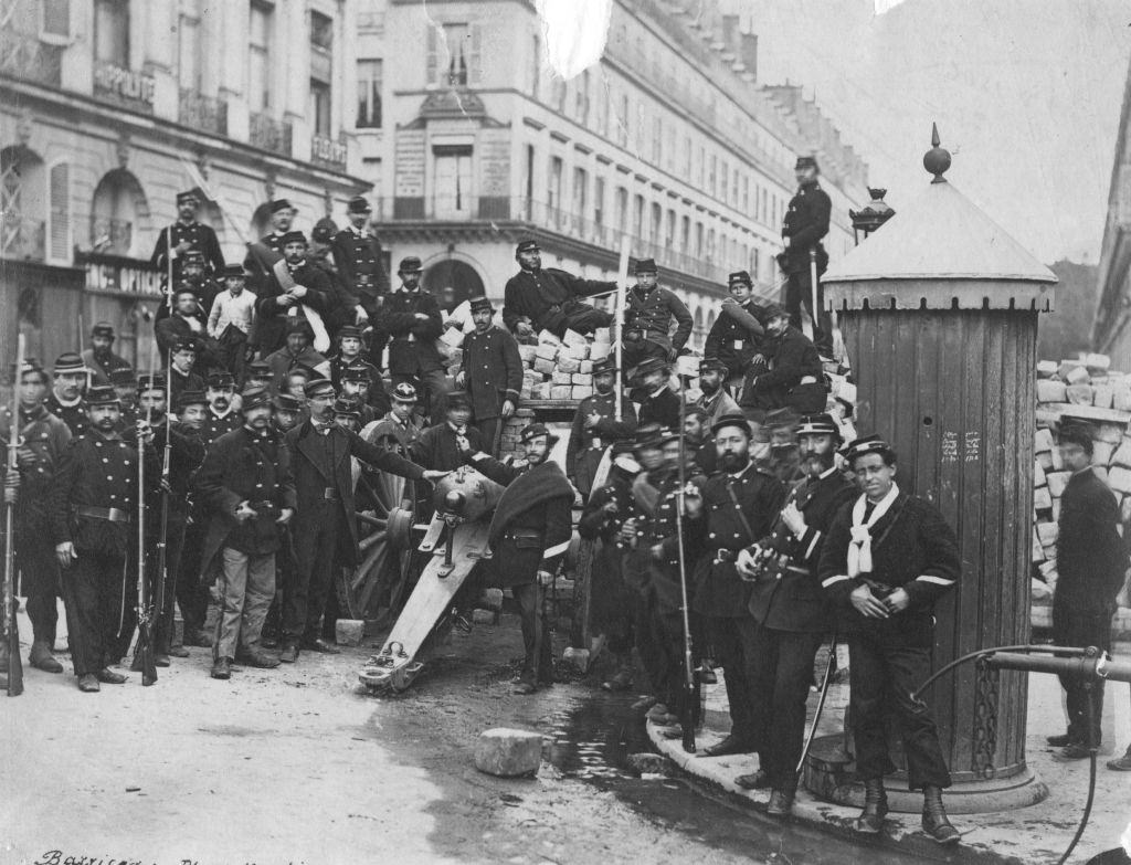 National guardsmen pose in front of an artillery barricade in the Place Vendome, following the Franco-Prussian War.