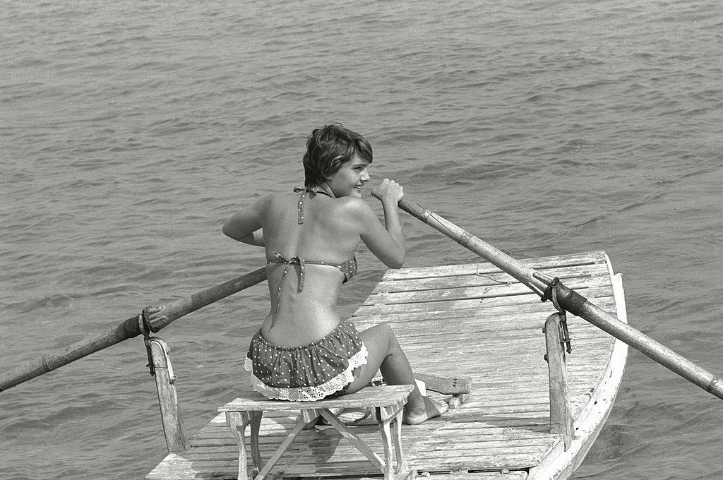 Italian actress Anna Magnani guest at the Film Festival laughs sitting near the actor James Mason. Venice, August 1956.