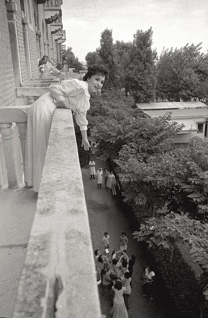 The actress Gina Lollobrigida leans toward her admirers from a terrace of a hotel room, during the 17th Venice Intenational Film Festival.