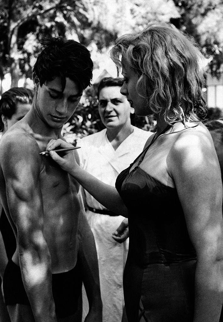 Italian actress and TV presenter Sandra Milo (Salvatrice Elena Greco) signing an autograph on the arm of a young man.