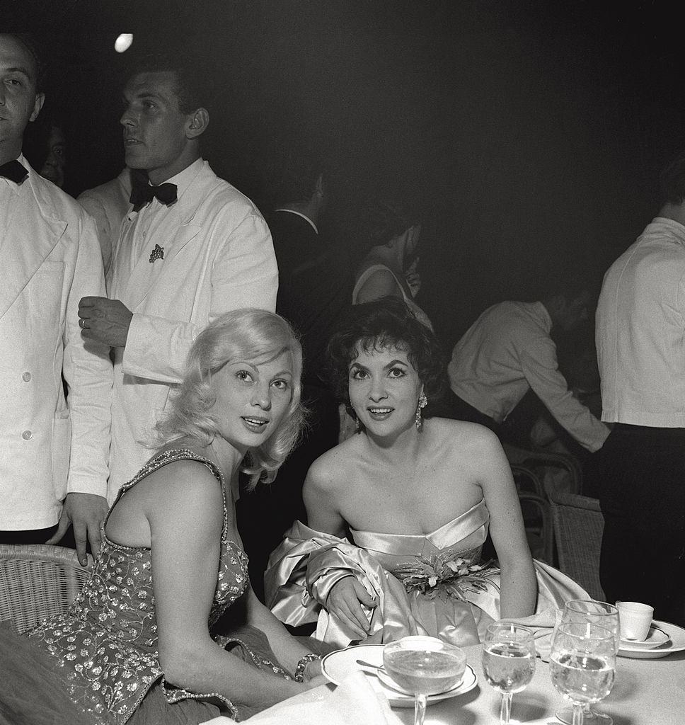 The actress Gina Lollobrigida is sitting at the table with an actress at the Venice Film Festival. 1956.