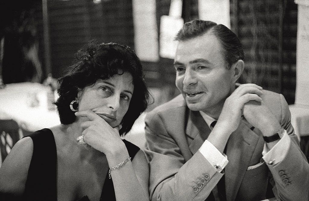 The actors Anna Magnani and James Mason make conversation together, sitting at a table, during the 17th Venice Intenational Film Festival.