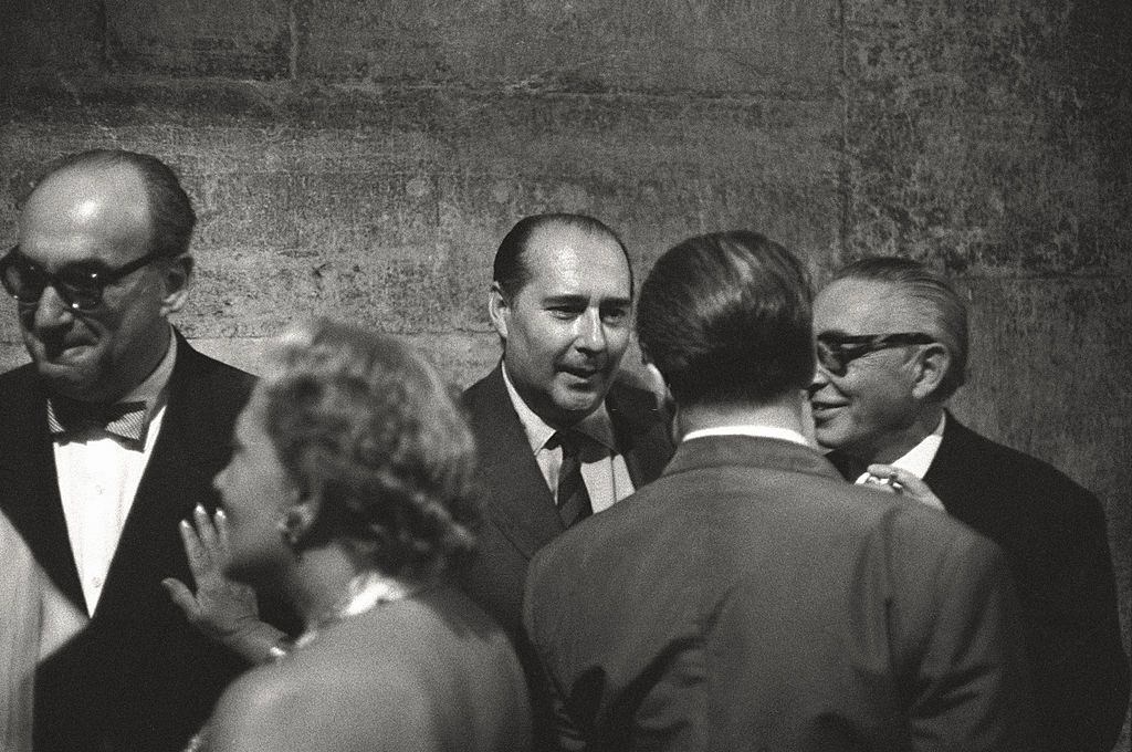 The director Roberto Rossellini making conversation in a social event in the course of the 17th Venice Intenational Film Festival.