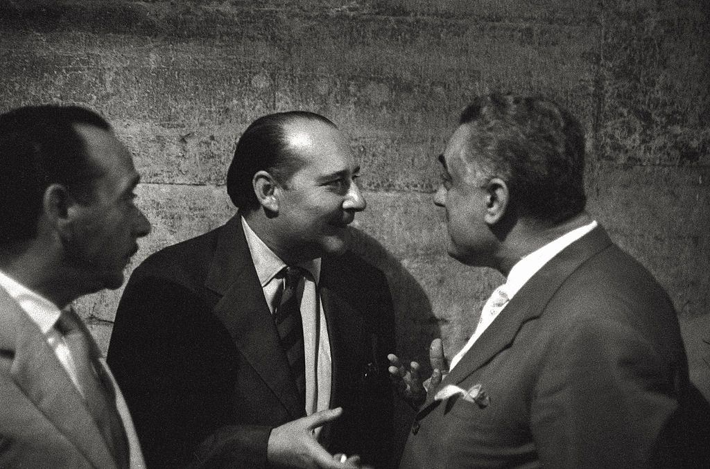 The director Roberto Rossellini making conversation in a social event in the course of the 17th Venice Intenational Film Festival.