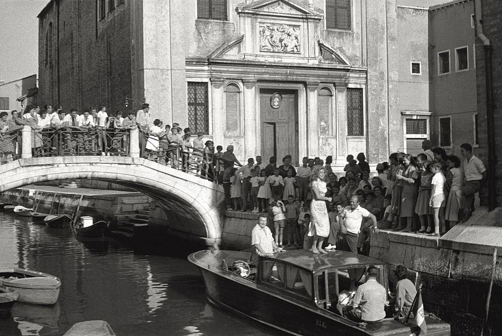 The actress Abbe Lane dancing on the roof of a boat, encircled with admirers during the 17th Venice Intenational Film Festival.