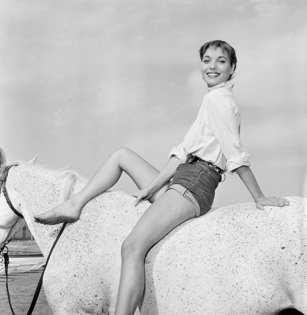 Italian actress and fashion model Elsa Martinelli enjoys a ride in the sea on Bill the horse.