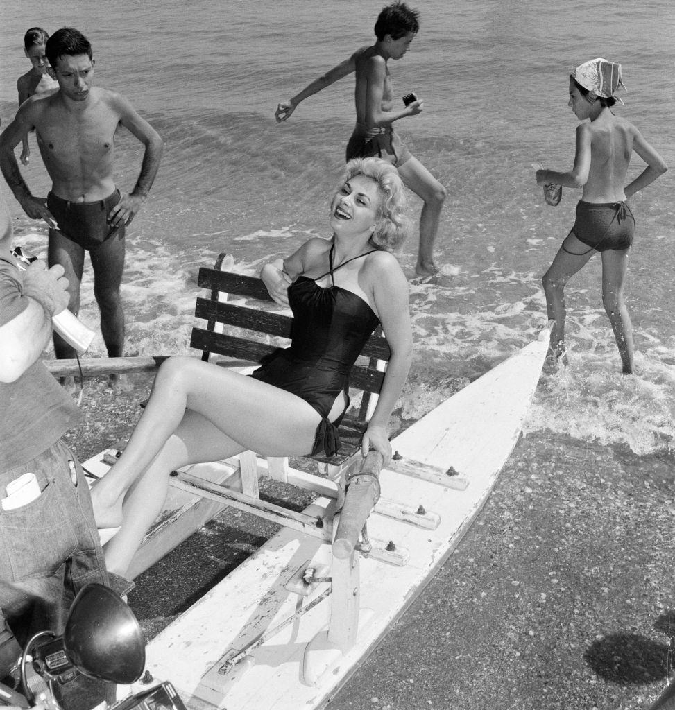 Italian actress Sandra Milo, poses for pictures as she sits on a Pedalo.