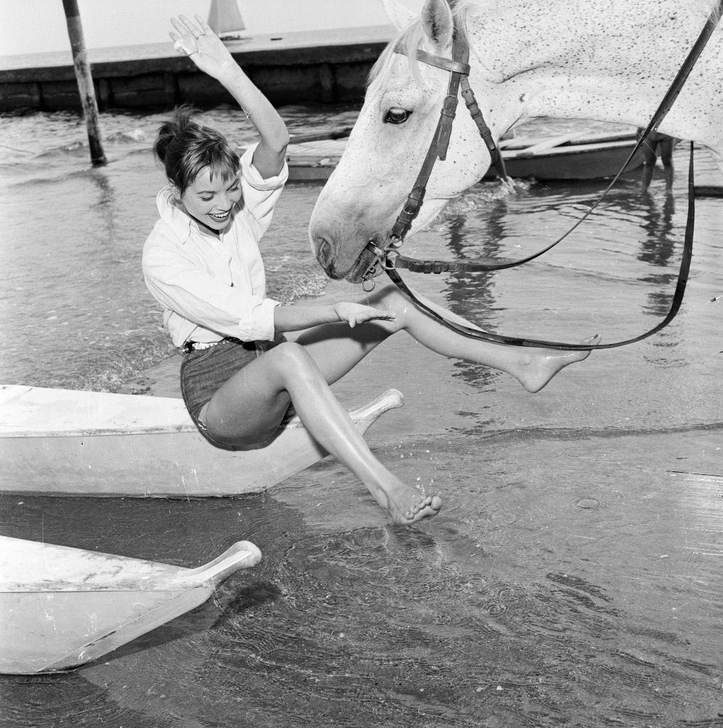 Italian actress and fashion model Elsa Martinelli enjoys a ride in the sea on Bill the horse.