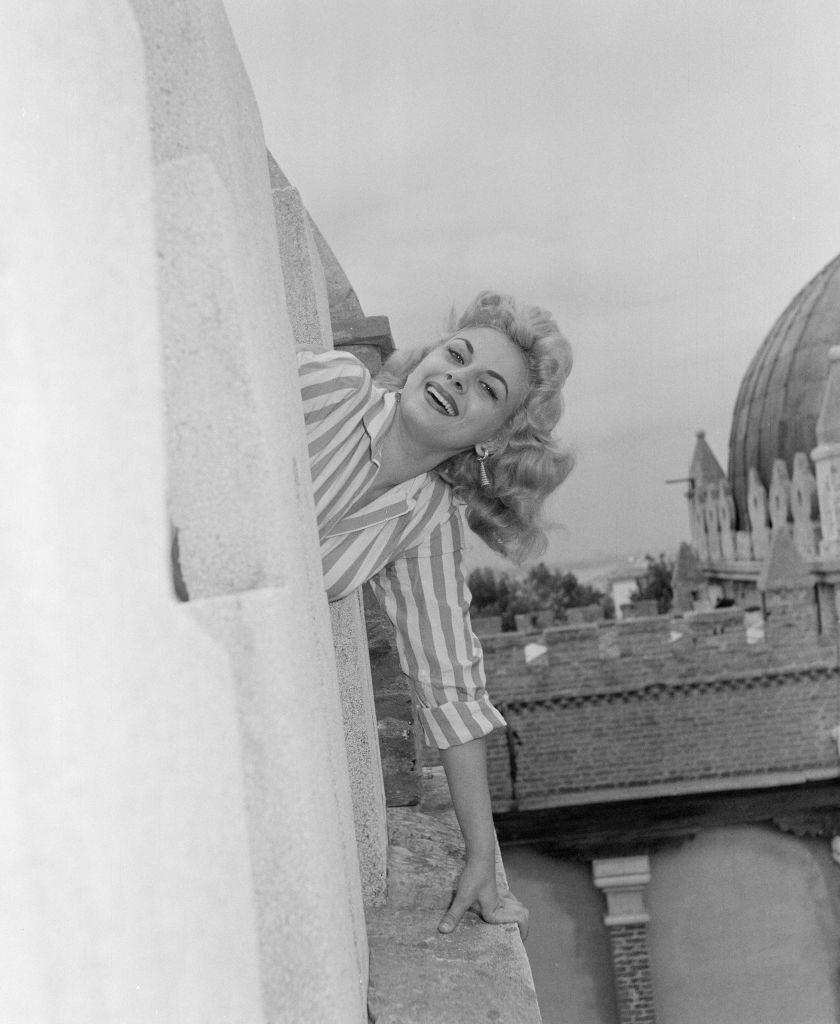 Italian actress Sandra Milo, wearing striped shirt and white shorts.