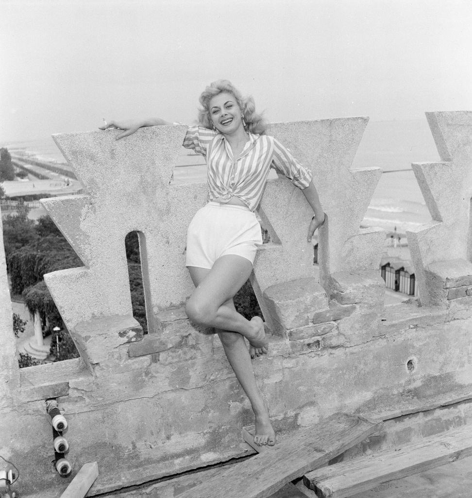 Italian actress Sandra Milo, wearing striped shirt and white shorts at 1956 Venice Film Festival.
