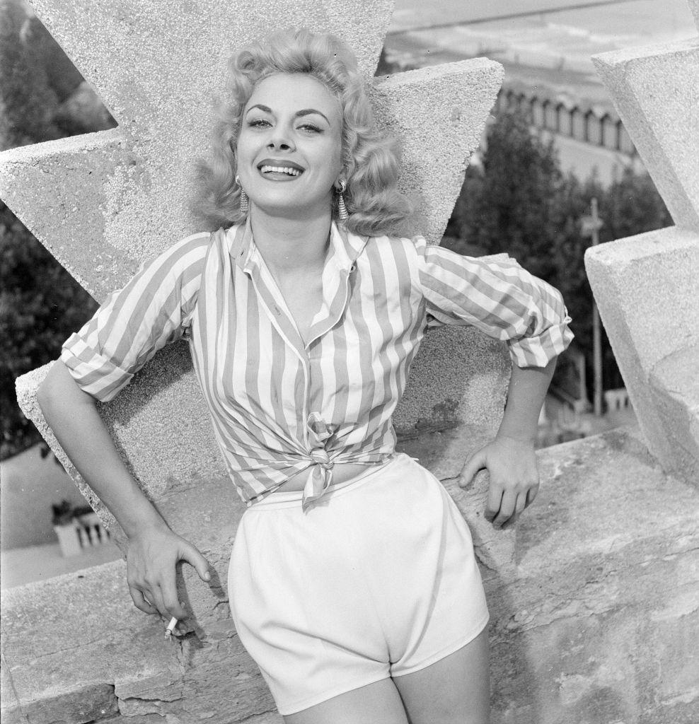 Italian actress Sandra Milo, wearing striped shirt and white shorts at 1956 Venice Film Festival.