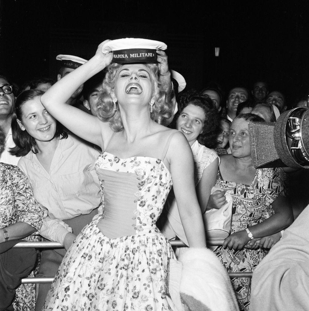 Italian actress Sandra Milo arrives at the Casino, applauded by fans and a member of the Italian navy.