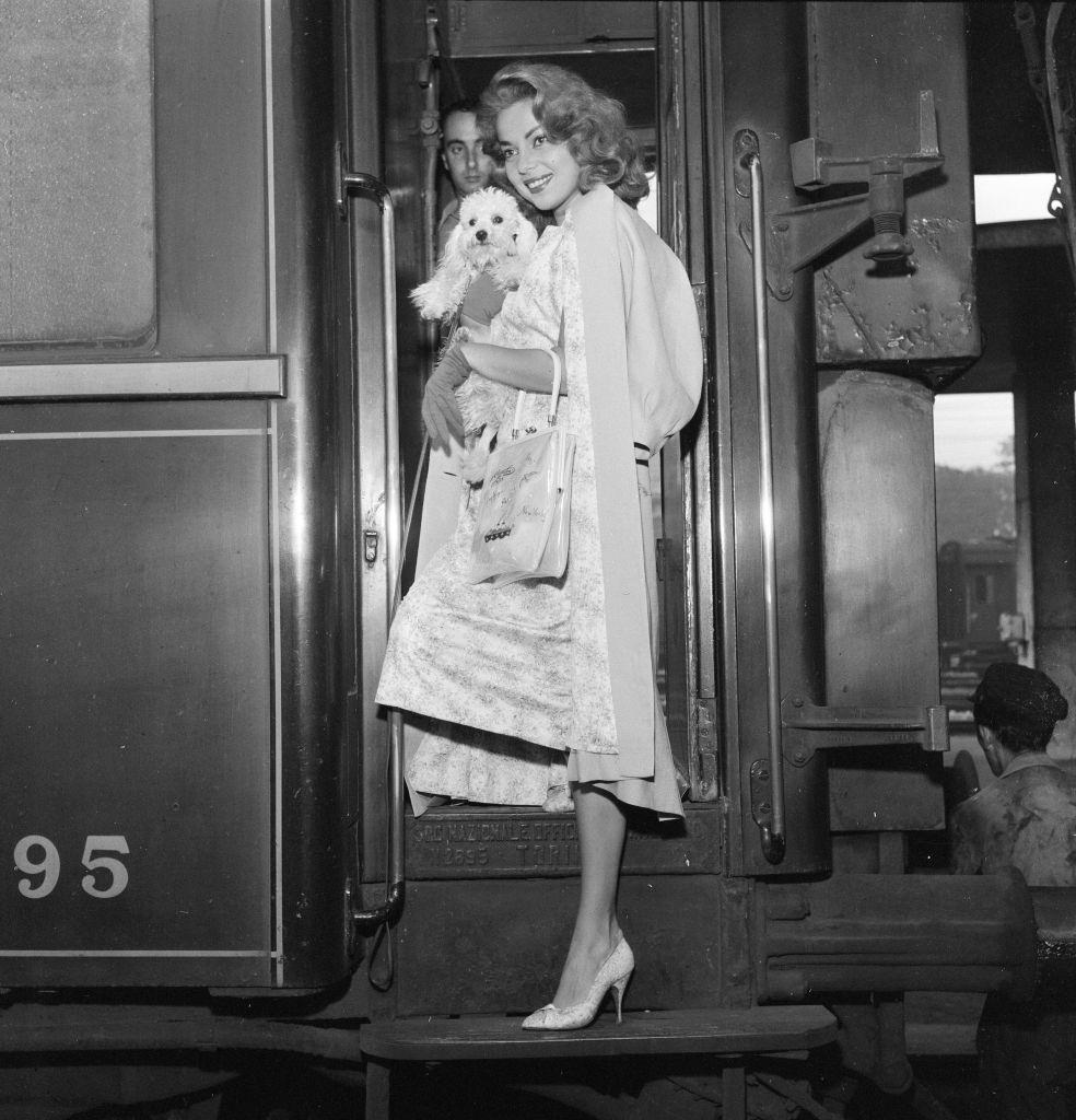 Abbe Lane, American singer and actress, arrives in Venice by train, pictured with her pet dog Suzette.