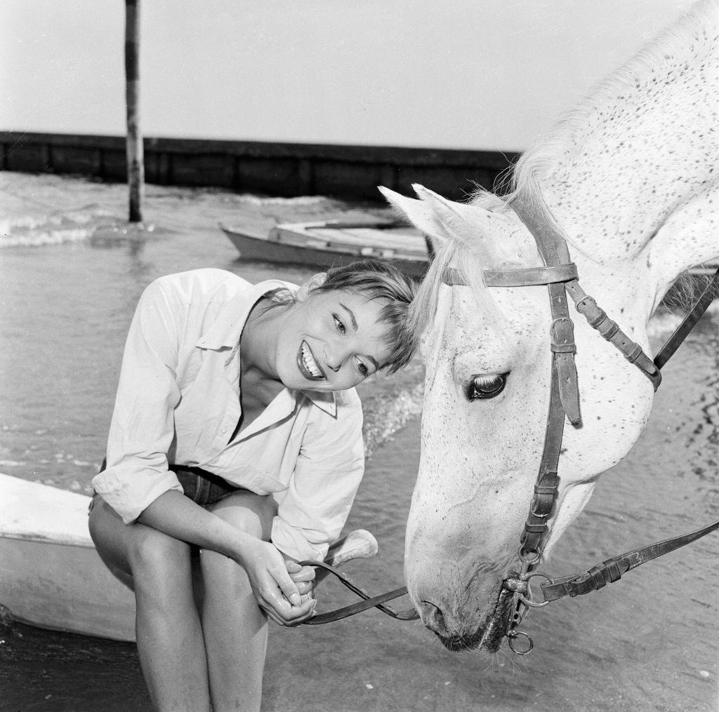 Italian actress and fashion model Elsa Martinelli enjoys a ride in the sea on Bill the horse at 1956 Venice Film Festival