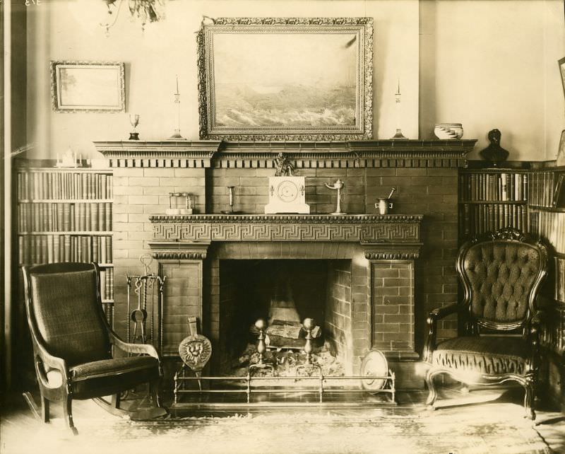 A view of the library mantle with Greek key pattern and the fireplace.