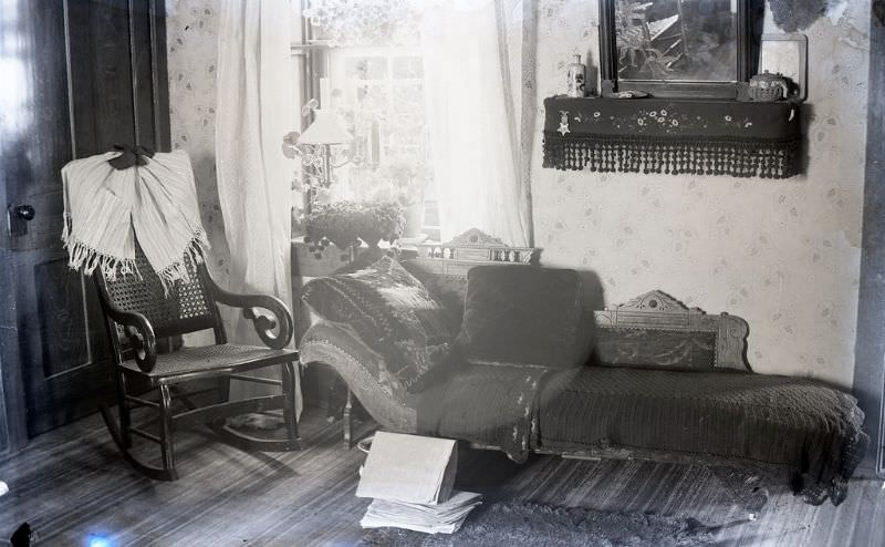 A view of the sitting room with a lounging sofa under the shelf, a crochet blanket covers the sofa.