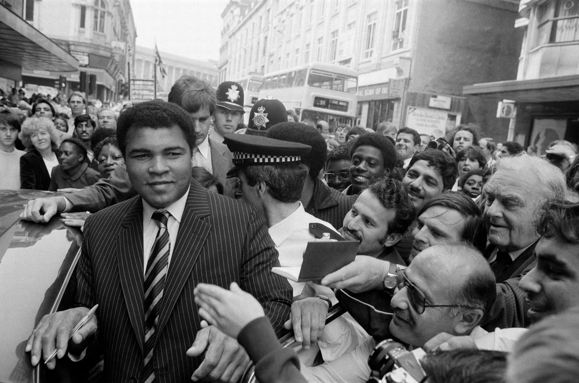 Muhammad Ali is mobbed by fans and supporters in the streets of Birmingham, 9th August 1983.